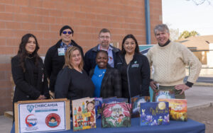 Back row from left Angelia Lopez, Dr. Jonathan Melk, Karl Griffor, Margarita Guevara, Denis Walto and front from left, Rachael Henry and Jacque Clay show off some of the 2,500 plus books Chiricahua Community Health Centers Inc. donated to the Reading Across Cochise County Initiative. Kevin Callison